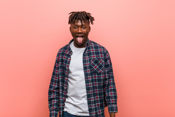 Young african black man funny and friendly sticking out him tongue.