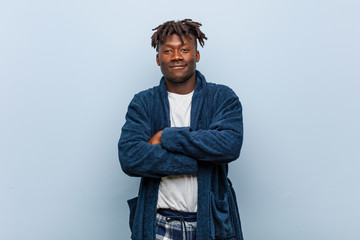 Young african black man wearing pajama smiling confident with crossed arms.