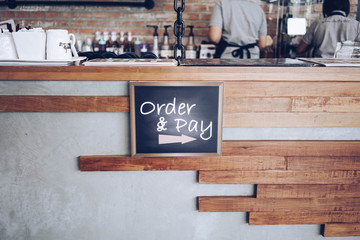 order and pay wooden chalkboard tag on counter bar in cafe or retail shop