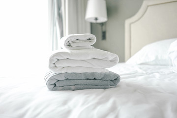 White and grey towel on bed decoration in bedroom interior