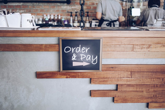 order and pay wooden chalkboard tag on counter bar in cafe or retail shop