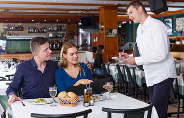 Fototapeta na wymiar Man and woman ordering food in restaurant