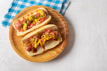 Hot dog with jalapeno pepper and tomato on white background