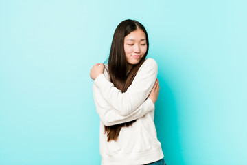 Young pretty chinese woman hugs, smiling carefree and happy.