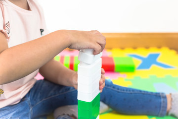  Little girl  playing with colorful toy blocks. Construction blocks.