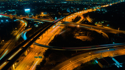 Fototapeta na wymiar Rail track and conductor rail transportation, Aerial top view, Road Expressway traffic highway roundabout transportation with moving cars and railway tracks on which the train rides