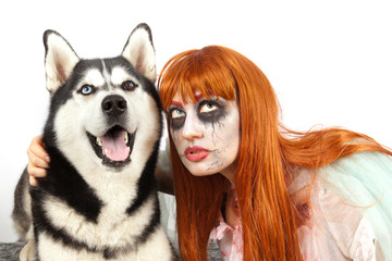 The red-haired girl in a zombie costume with different eyes and a dog Siberian Husky with different eyes, too