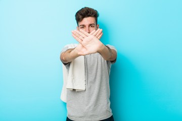Young fitness teenager man doing a denial gesture