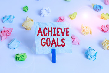 Handwriting text Achieve Goals. Conceptual photo Results oriented Reach Target Effective Planning Succeed Colored crumpled papers empty reminder white floor background clothespin