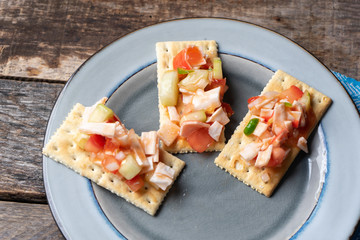 Surimi crab ceviche with cucumber and tomato on wooden background