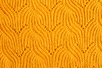 Knitted texture of an orange sweater. Background of orange textured sweaters. Fall background