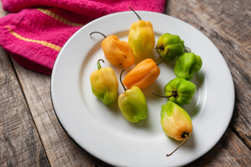 Raw habanero peppers on wooden background