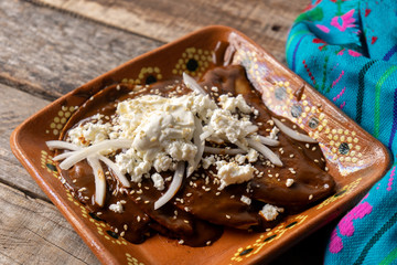 Mexican mole sauce enchiladas with cheese and sesame seeds