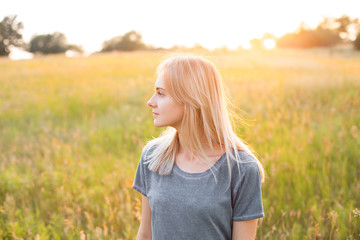 Portrait of young woman on the field at evening