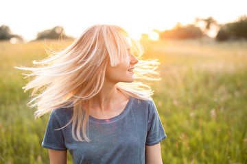 Portrait of young woman with beautiful blond hair outdoors.