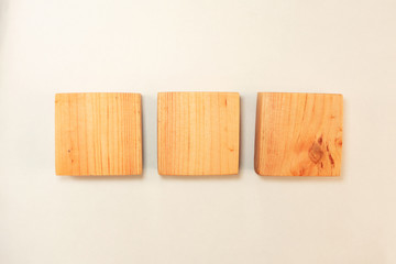 Wood square bar pieces with shadows on white background. Horizontal row of wooden squares as concept of kids development toy, construction or decoration. Mockup stairs or diagram elements
