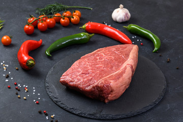 Raw fresh marbled meat and seasonings on dark background
