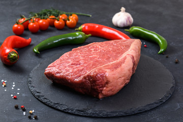 Raw fresh marbled meat and seasonings on dark background