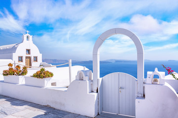 Traditional white architecture and door overlooking the Mediterranean sea in Oia Village on Santorini Island, Greece. Scenic travel background. - obrazy, fototapety, plakaty