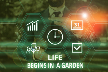 Word writing text Life Begins In A Garden. Business photo showcasing Agriculture Plants growing loving for gardening Male human wear formal work suit presenting presentation using smart device