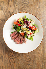 salad with beef on the wooden background