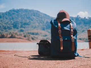 spring season activity concept from camera bag and outdoor backpack of traveler or photographer man put on floor of street with lake view in morning time background
