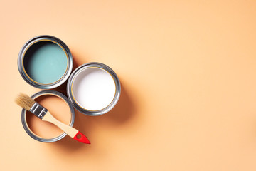 Paint brush and open paint can with on pastel background. Top view, copy space. Appartment renovation, repair, building and home design concept.