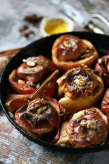 Baked apples in a pan with cinnamon, honey and spices. Healthy autumn dessert. The diet is friendly. Vegan Dessert. Selective focus. Macro.