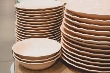 Piles of clean white dishes in the dining room. Food court in a shopping center, catering.