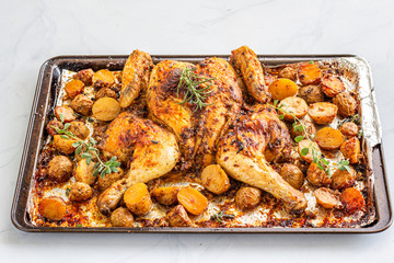 Spatchcocked barbecue chicken with Potatoes on a Baking Tin on White Background, Directly Above Photo. Oven Roasted .Spatchcock Chicken on White Background.