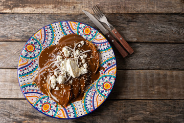 Mexican mole sauce enchiladas with cheese and sesame seeds - obrazy, fototapety, plakaty
