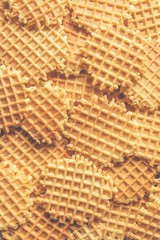 Sweet crispy waffles heap top view, vertical image