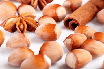 composition of anise, cinnamon stick, hazelnut isolated on white background