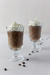 Coffee Chia pudding in glass on white wooden background. This is a useful product for those who lead a healthy lifestyle, for vegetarians.