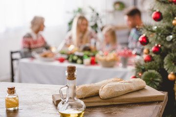 selective focus of baguettes on cutting board and oil in bottle