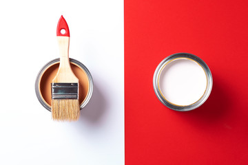 Wooden paint brush, open paint cans on trendy red and white background. Top view, copy space. Appartment renovation, repair, building and home design concept.