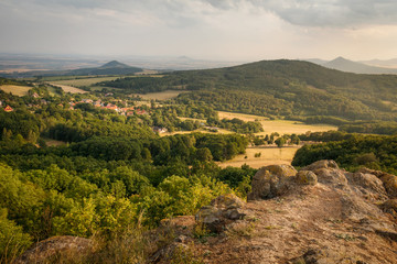 Obraz premium Summer sunset on the view point above the deep valley in Ceske stredohori mountains Lysa Hora, Czechia