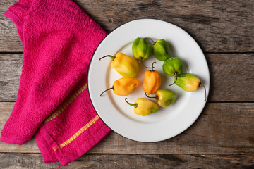 Raw habanero peppers on wooden background
