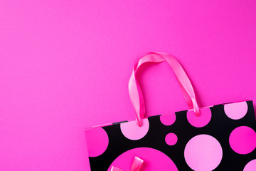 Black friday sale concept. Top view of pink paper shopping bag on trendy bright background. Copy space. Woman's day. Valentine's day. Ready for birthday party.