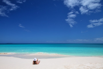 Fototapeta na wymiar Woman relaxing on Fayaoue beach on the coast of Ouvea lagoon, Mouli and Ouvea Islands, New Caledonia