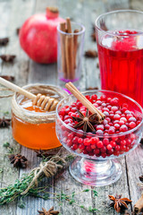 Warm cranberry tea with honey and pomegranate. Wood background.