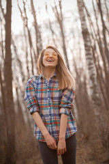 Young woman walking in autumn forest and laughing