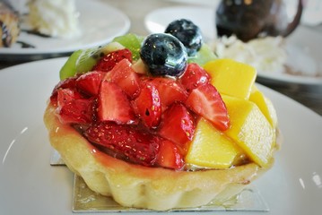 Cobbler tarts on wood tables, mango, strawberries, kiwi, blueberries