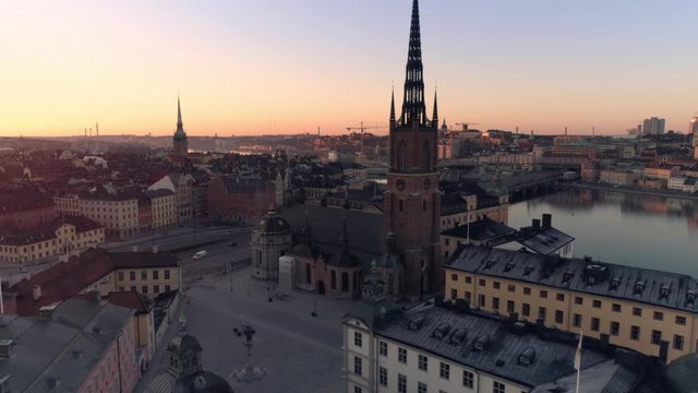 Stockholm skyline at sunrise aerial view. Drone shot flying over Riddarholmen island city buildings and church. Gamla stan, Old Town landmark, Capital of Sweden