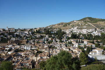 Fototapeta na wymiar Point de vue de l'Alhambra sur le quartier blanc de Grenade : l'Albaicin et les montagnes au loin