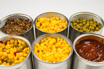 Canned food on white background. Green pea, beans, corn, lentils.