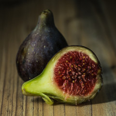 A fig and half on a table. Black background.