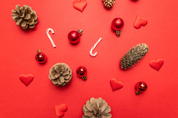 Christmas composition with pine cones, Christmas decoration silver stars, candy canes on red background