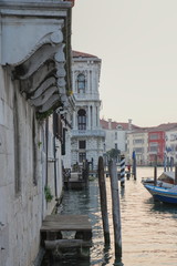 A very small wooden pier at the base of a house on the water, Venice, the sun goes down