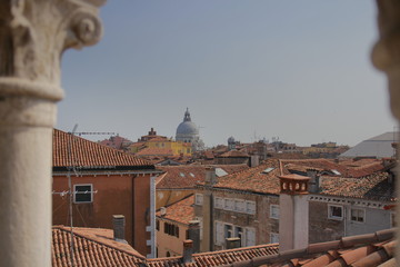 View of Venice from the tower of the Palace of Contarini del Bovolo, selected focus - columns from the arch of the window in defocus, roofs and buildings in focus